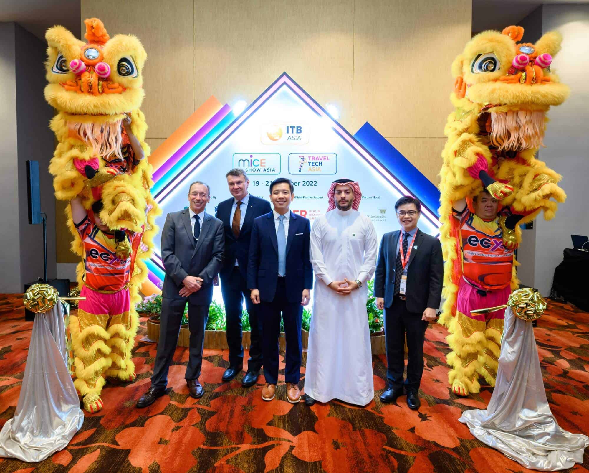 Vibrant lion dance performance with international visitors celebrating at ITB Asia trade show in Singapore.