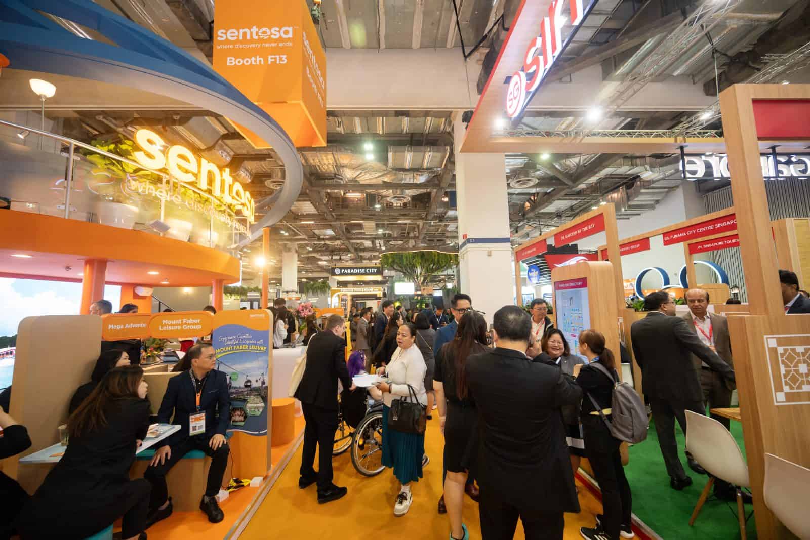 Sentosa booth at ITB Asia trade show in Singapore, vibrant exhibition with attendees networking.