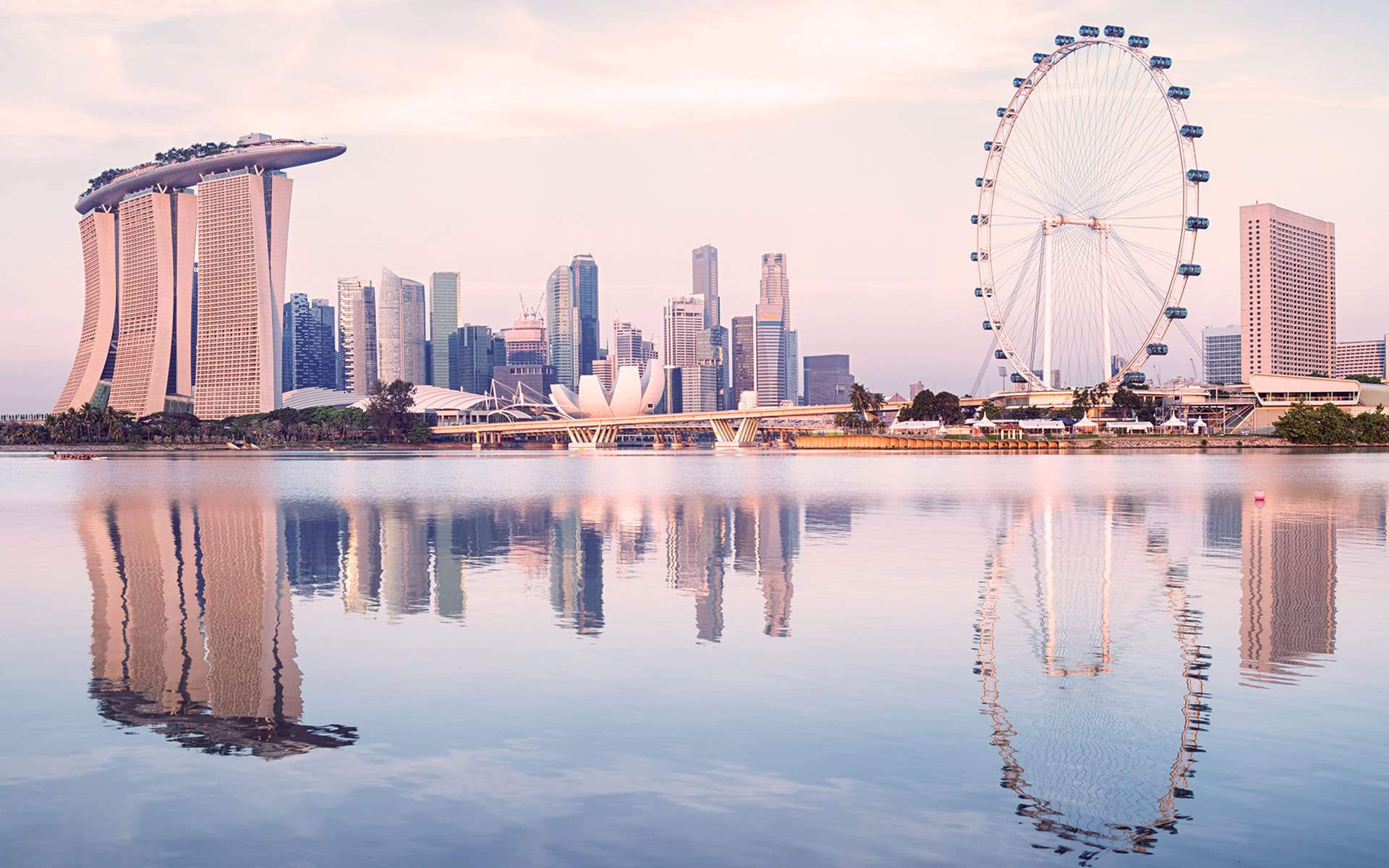 Breathtaking view of Singapore skyline with Marina Bay Sands and Singapore Flyer at sunset, showcasing the city’s iconic landmarks.