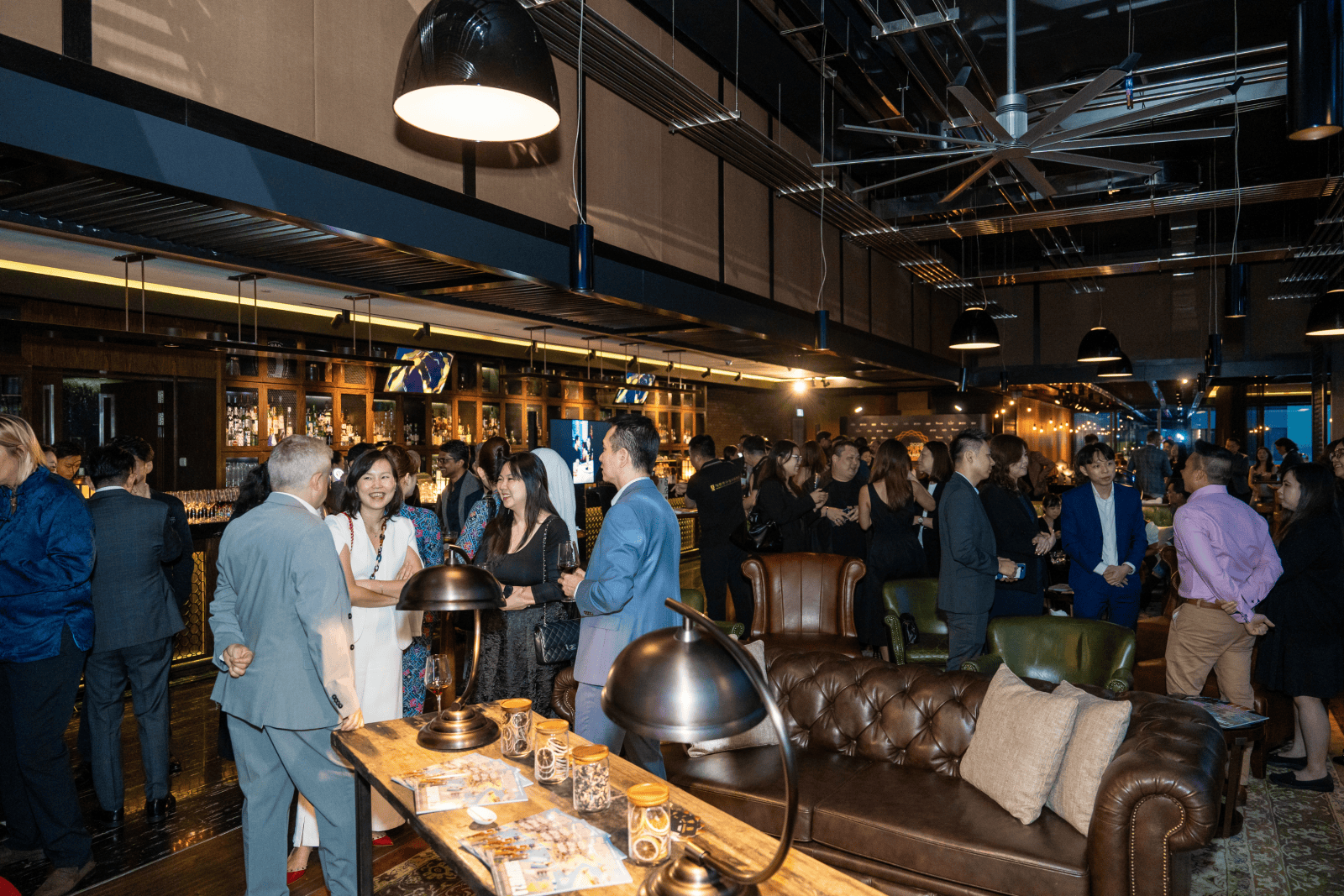 Business professionals networking at a corporate event in a modern venue.