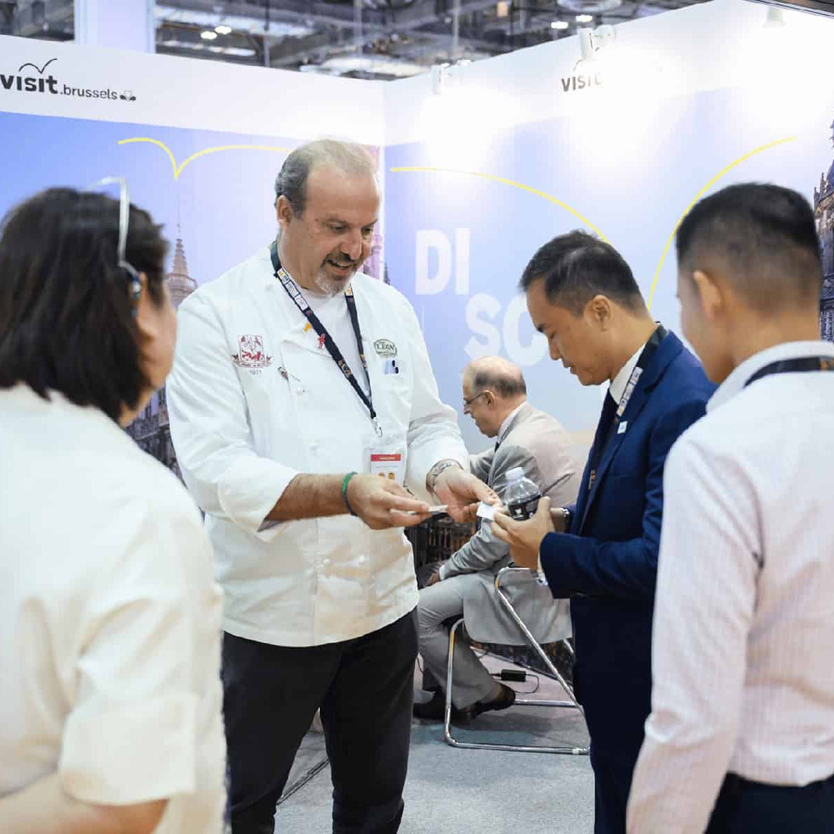Diverse attendees engaging at the ITB Asia 2026 travel trade show booth in Singapore.