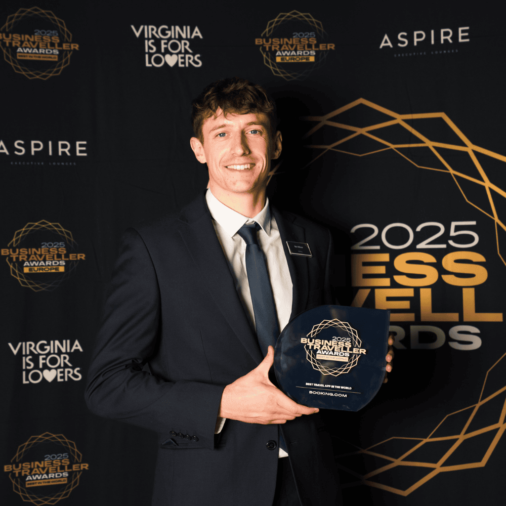 Young man in formal suit holding award at ITB Asia 2026 event in Singapore.