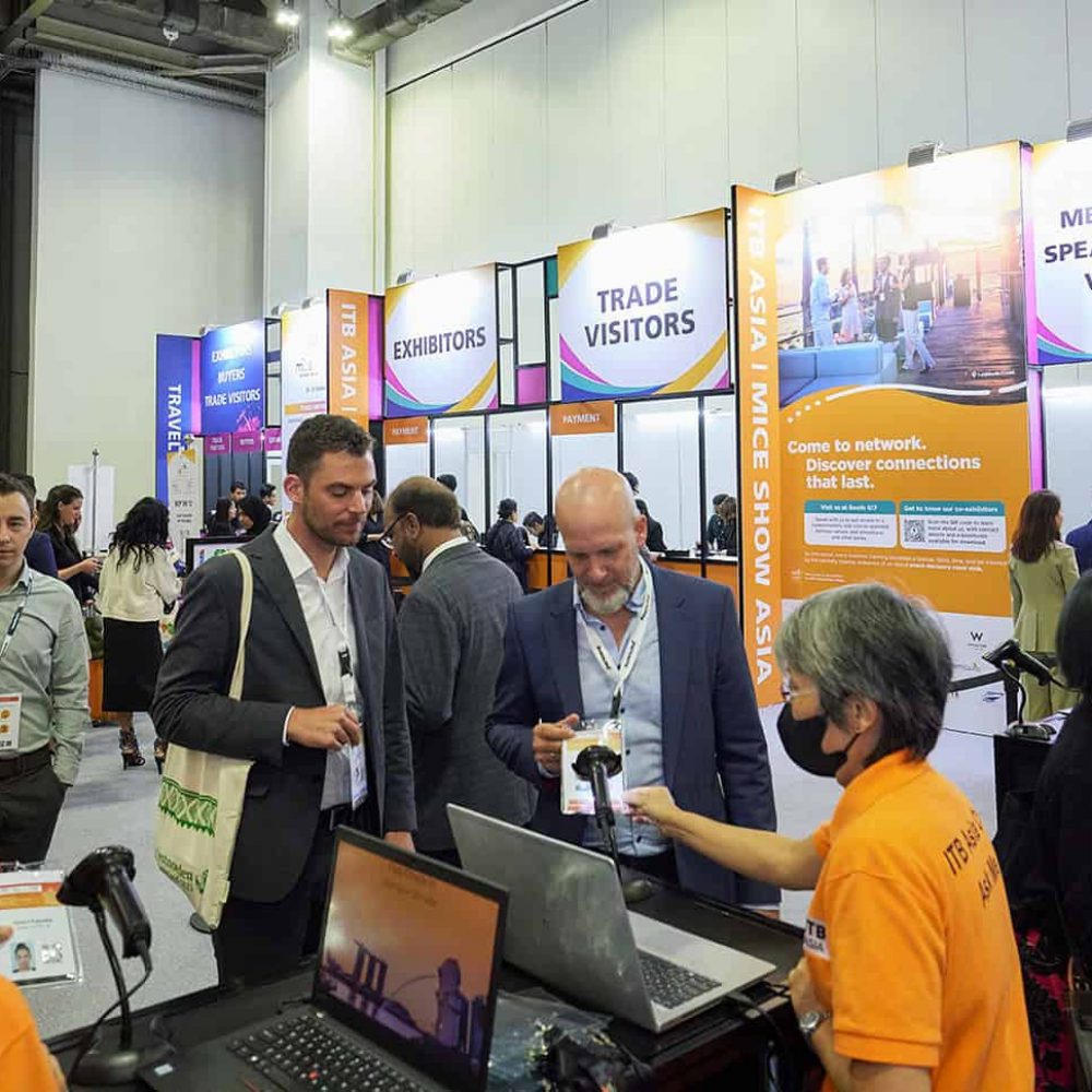 Trade show attendees engaging at ITB Asia 2026 travel trade event in Singapore, showcasing industry connections.