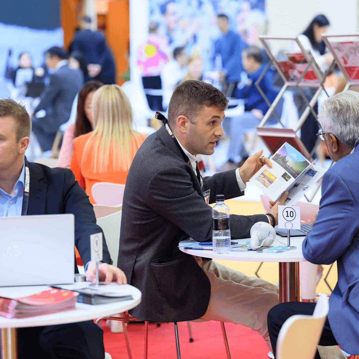 Small group of business professionals engaging in discussions at ITB Asia 2026 travel trade show in Singapore.